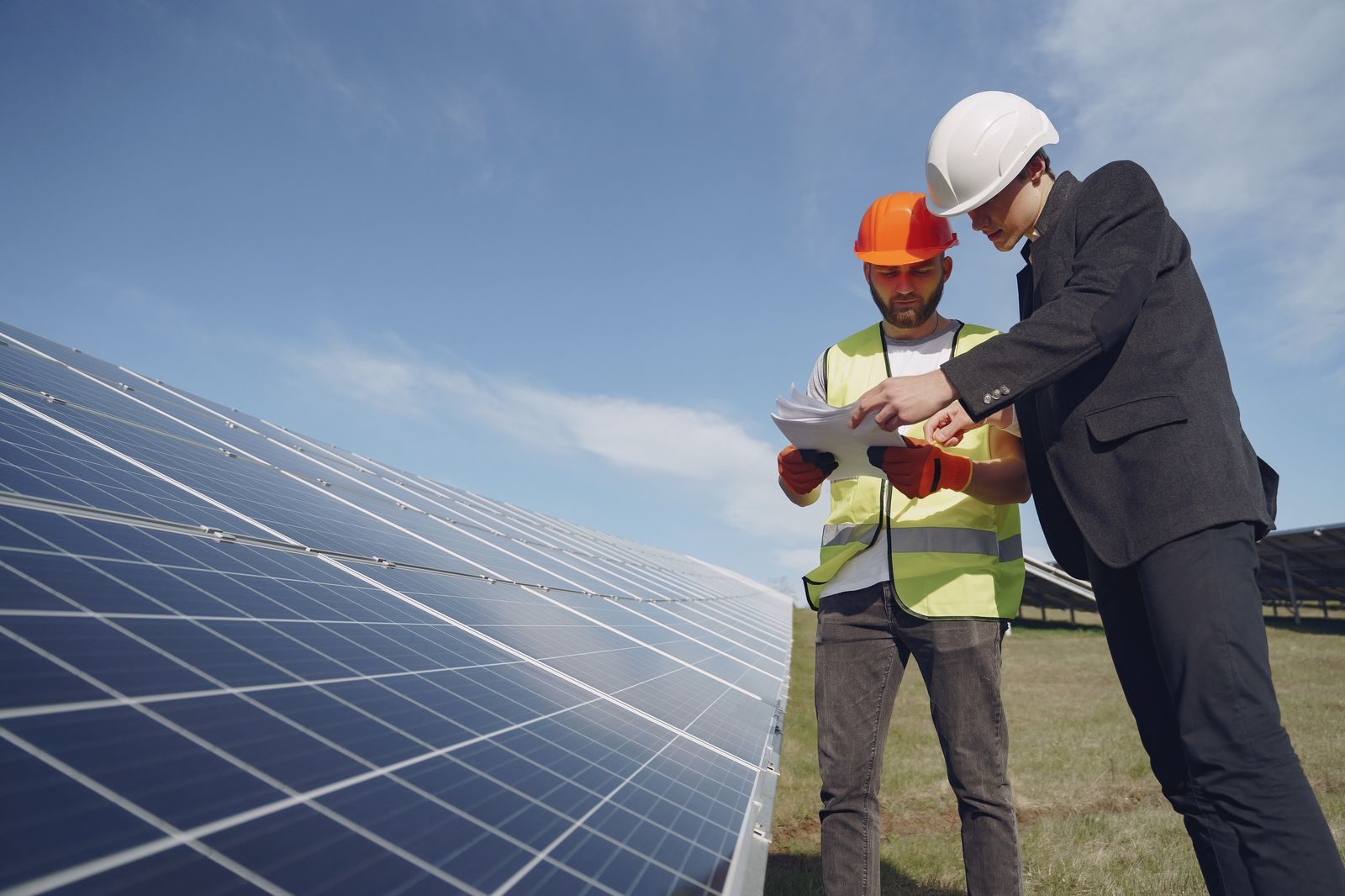 An advisor and an engineer reviewing plans at a solar project site